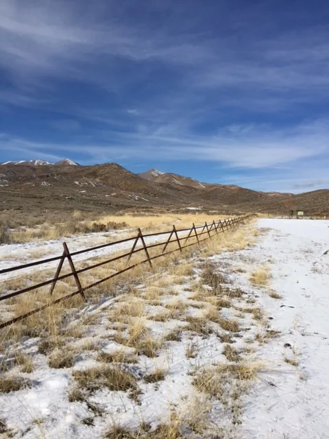 Steel jack fence on a snowy Idaho hillside under a blue sky