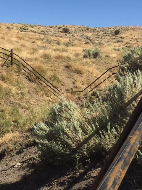 Steel jack fence running up a sagebrush hillside in Idaho