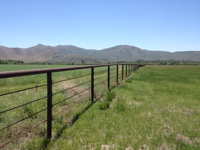 Steel pipe fence built to last across an open Idaho field